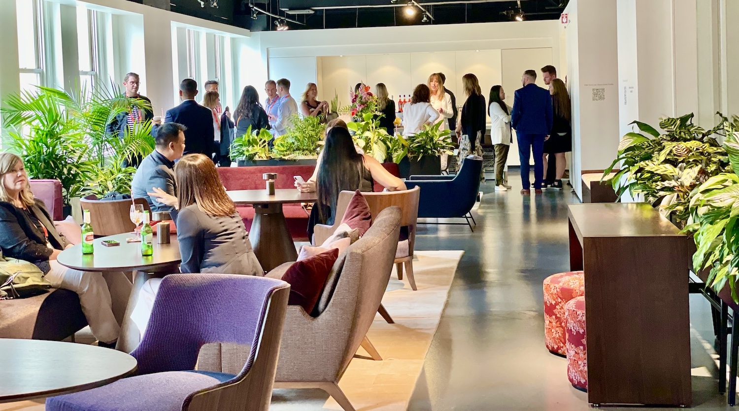 A group of people in the HBF showroom at NeoCon 2022. In the image are also several plants decorating the space